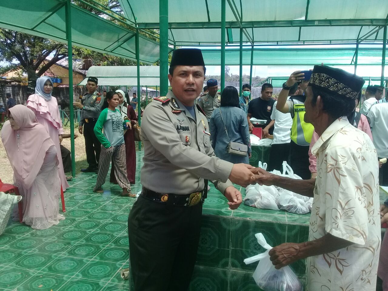 Kapolres Muna, AKBP Agung Ramos Paretongan Sinaga saat memberikan daging kurban kepada salah seorang masyarakat
