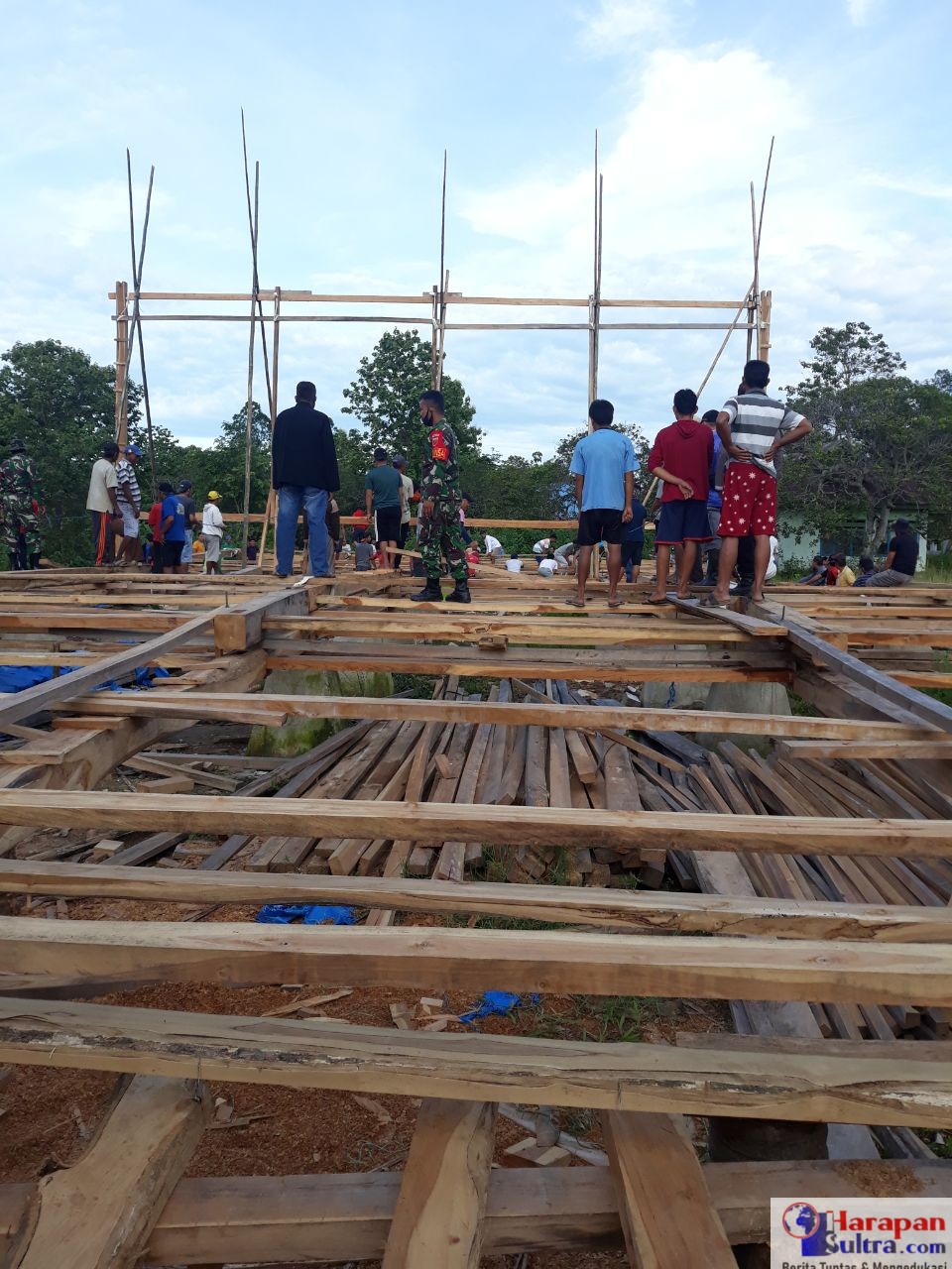 Babinsa saat membantu warga mendirikan Rumah Adat Moronene