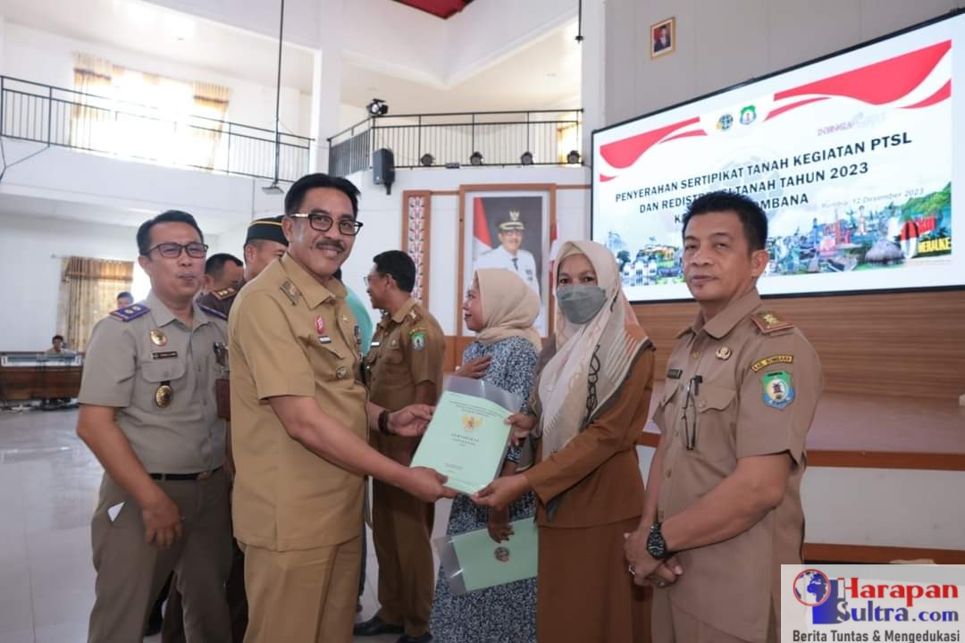 Penjabat (Pj) Bupati Bombana, Edy Suharmanto (2 dari kiri) didampingi Kepala Kantor BPN Kabupaten Bombana, Tageli Lase (kiri) menyerahkan sertifikat tanah kepada masyarakat, di Aula Tanduale Kantor Bupati Bombana.( Sumber Foto : Diskomfo Bombana )