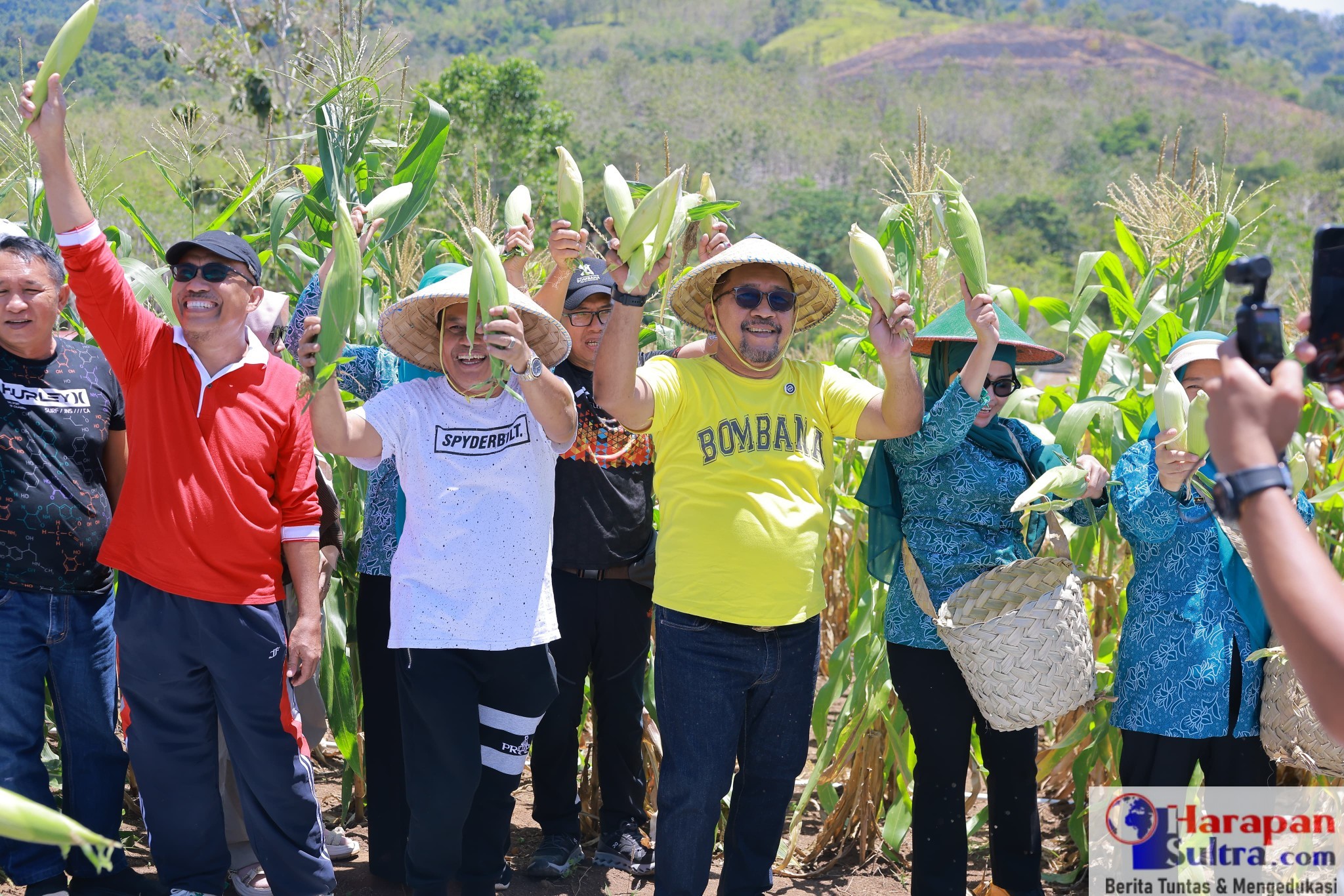 Panen Sukses: Bupati Bombana Ir. H. Burhanuddin, M.Si. (tengah, berbaju kuning) bersama Ketua TP-PKK Hj. Fatmawati Kasim Marewa dan jajaran, mengangkat hasil panen jagung di Kebun Percontohan PKK Langkapa, Rarowatu, sebagai wujud dukungan terhadap program ketahanan pangan keluarga.